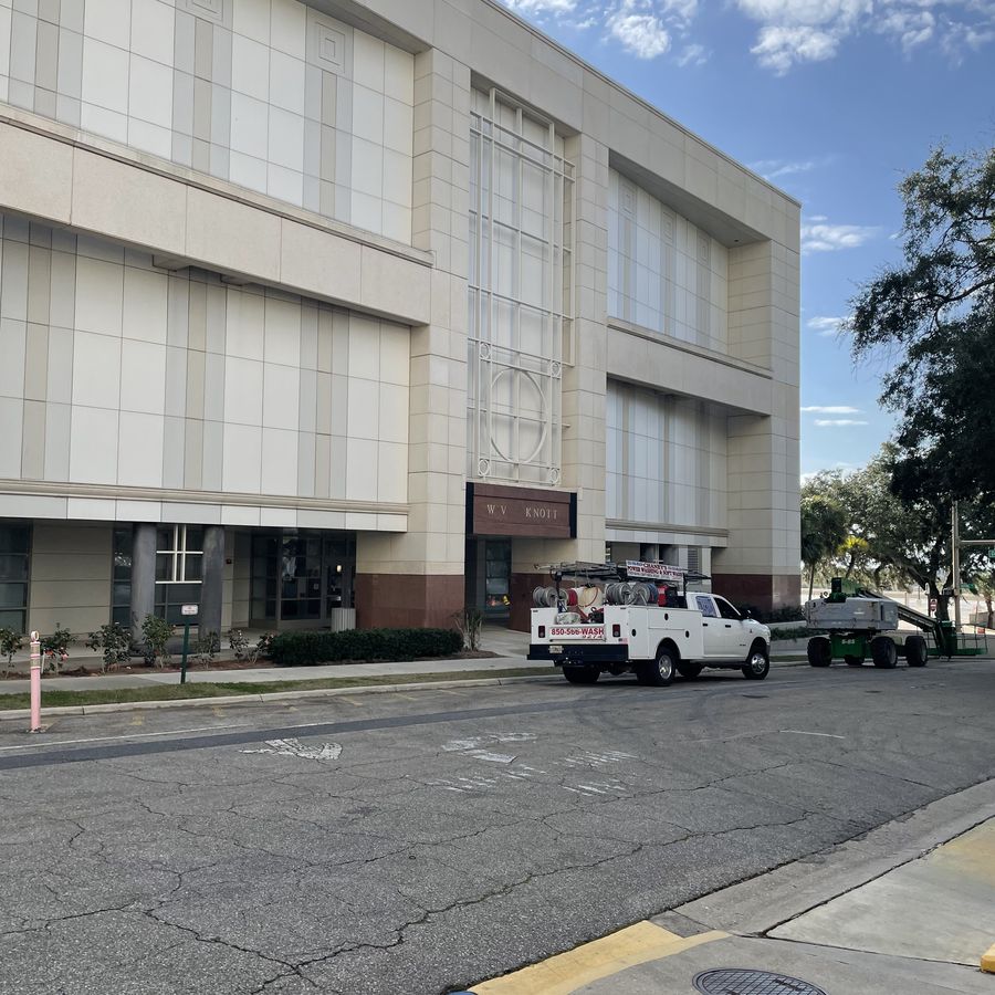 A Chaney's truck and a lift staged outside a multi-storey stone-clad office building.